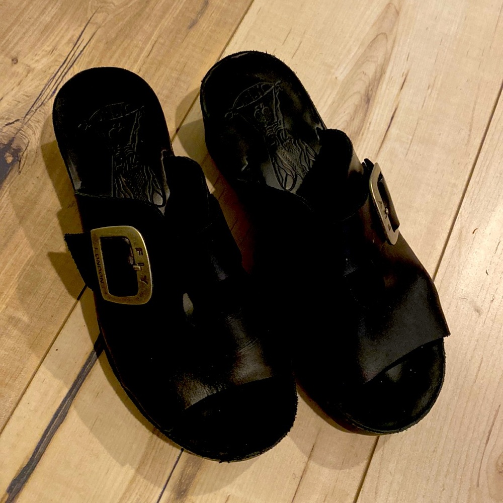 Fly London sandals size 6.5 in black and a buckle on the top.